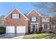 Charming brick two-story home with a two-car garage and lush front lawn and dark blue shutters at 2869 Amesbury Nw, Kennesaw, GA 30144