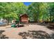 Community playground with swings and slide surrounded by trees, ideal for recreation at 2869 Amesbury Nw, Kennesaw, GA 30144