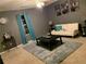 Comfortable living room with a gray carpet, a white couch, and turquoise curtains at 6706 Sunset Valley Cir, Rex, GA 30273