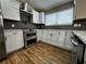 Modern kitchen with stainless steel appliances, white cabinets, and sleek backsplash for cooking at 3817 Raiders Ridge Dr, Lithonia, GA 30038