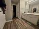 A bathroom featuring a vanity, sink, mirror and wood-look vinyl flooring at 3835 Pleasant Oaks Dr, Lawrenceville, GA 30044