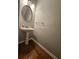 Powder room featuring pedestal sink, oval mirror, and attractive hardwood flooring at 3835 Pleasant Oaks Dr, Lawrenceville, GA 30044