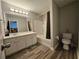 A bathroom with a vanity, sink, mirror, vinyl floor, tub and toilet at 3835 Pleasant Oaks Dr, Lawrenceville, GA 30044