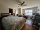 A bedroom with a wood framed bed, ceiling fan, hardwood floors and a sitting area at 3835 Pleasant Oaks Dr, Lawrenceville, GA 30044