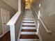 Carpeted staircase with white risers and handrail leading to the upper level at 3835 Pleasant Oaks Dr, Lawrenceville, GA 30044
