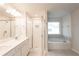 A well-lit bathroom boasting a glass-enclosed shower, soaker tub, and dual sinks with modern fixtures at 4853 Walkers Green, Mableton, GA 30126