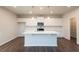 Modern kitchen featuring white cabinets, a center island, stainless steel appliances, and hardwood flooring at 4853 Walkers Green, Mableton, GA 30126
