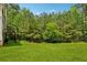 Large, grassy backyard with a deck and tree line. Perfect for outdoor activities at 4240 N Braves Cir, Douglasville, GA 30135
