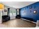 Comfortable living room featuring a blue accent wall and hardwood floors at 4240 N Braves Cir, Douglasville, GA 30135