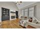 Spacious living room with hardwood floors, a fireplace, and black built-in bookcases at 5810 Ripplestone Nw Ct, Acworth, GA 30101
