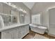 Bright bathroom featuring double sinks, a standalone tub, and modern fixtures at 5810 Ripplestone Nw Ct, Acworth, GA 30101