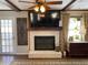 Cozy living room featuring a brick fireplace, mounted television, and hardwood floors with area rug at 170 Dillard Ne Dr, Kennesaw, GA 30144