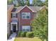 Attractive townhome featuring brick accents, manicured bushes, and lush green lawn at 2612 Halligan Pointe, Riverdale, GA 30296