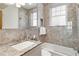 Elegant bathroom with marble tile, bathtub, and a shower with glass door at 30 Collier Nw Rd # 6, Atlanta, GA 30309