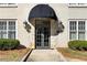 Building entrance with stone accents, coach lights, and manicured shrubs at 30 Collier Nw Rd # 6, Atlanta, GA 30309