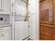 Functional laundry area with a stacked washer and dryer, adjacent to a unique wooden door at 30 Collier Nw Rd # 6, Atlanta, GA 30309