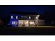 Backyard view of home with well-lit patio area, hot tub, grill, and lush green lawn at night at 2903 Eva Clb, Acworth, GA 30101