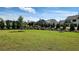 Spacious backyard with plush green grass, landscaping, and privacy trees at 2903 Eva Clb, Acworth, GA 30101