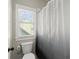 Bright bathroom featuring a toilet and shower with a window providing natural light at 2903 Eva Clb, Acworth, GA 30101