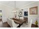 Elegant dining room featuring a modern chandelier, wainscoting, and hardwood floors at 2903 Eva Clb, Acworth, GA 30101