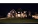 Inviting home exterior at night with a lush lawn and stone-accented entrance. American flag included at 2903 Eva Clb, Acworth, GA 30101