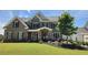 Elegant brick home featuring a stone entryway, shutters, and professionally landscaped yard at 2903 Eva Clb, Acworth, GA 30101
