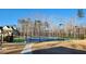 Community tennis court area with black metal fence, lighting, and walkable path at 2903 Eva Clb, Acworth, GA 30101