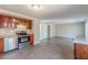 Spacious kitchen with stainless steel appliances and wood cabinets, flowing into an open-concept living area at 3344 Creekwood Dr, Rex, GA 30273