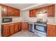 Cherry wood cabinets and stainless appliances in this well-lit galley-style kitchen at 3344 Creekwood Dr, Rex, GA 30273