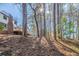 Wooded backyard featuring mature trees, a brick chimney, and a deck at 3777 Clubhouse Way, Conyers, GA 30094