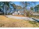 A long driveway leads to a gray two-story home nestled among tall trees, showcasing its expansive lot at 3777 Clubhouse Way, Conyers, GA 30094
