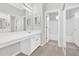 Bright bathroom featuring dual sinks, large mirror and white vanity at 627 W Oaks Dr, Woodstock, GA 30188