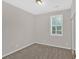 Well-lit bedroom featuring a window with shutter style blinds and carpet at 627 W Oaks Dr, Woodstock, GA 30188