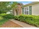 A view of home's stone facade, trimmed lawn, and green shrubs along sidewalk at 627 W Oaks Dr, Woodstock, GA 30188