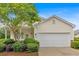 Charming home with a two-car garage and beautiful landscaping, including mature trees and lush bushes at 627 W Oaks Dr, Woodstock, GA 30188
