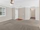 Inviting living room with neutral carpeting, a ceiling fan and view to kitchen and front entry at 627 W Oaks Dr, Woodstock, GA 30188