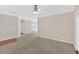 Spacious living room featuring neutral carpet, access to the kitchen and a modern ceiling fan at 627 W Oaks Dr, Woodstock, GA 30188