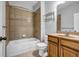 Bathroom with tiled shower and tub, wooden vanity, and natural light at 1992 Cobblestone Ne Cir, Brookhaven, GA 30319