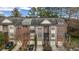 Townhome exterior showcasing brick facade, varied rooflines, garages, and neat landscaping at 1992 Cobblestone Ne Cir, Brookhaven, GA 30319