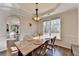 Sunny dining room featuring wood floors, a modern light fixture, and a view to the outside and other rooms at 3202 Monarch Pine Dr, Peachtree Corners, GA 30071