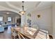 Open dining room with wood floors, stylish light fixture, and access to the kitchen and living area at 3202 Monarch Pine Dr, Peachtree Corners, GA 30071