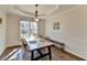 Traditional dining room featuring hardwood floors, a large window, decorative lighting, and a long dining table at 3202 Monarch Pine Dr, Peachtree Corners, GA 30071