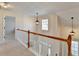 Light and airy hallway with wood railing and hanging lights at 3202 Monarch Pine Dr, Peachtree Corners, GA 30071