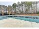 An in-ground swimming pool is covered for the off season and surrounded by a fence and tall trees at 3202 Monarch Pine Dr, Peachtree Corners, GA 30071