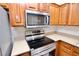 Modern kitchen featuring stainless steel appliances, wood cabinets, and speckled countertops at 506 Summer Pl, Norcross, GA 30071