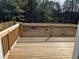 Wooden back deck with railing, perfect for outdoor relaxation and enjoying the natural scenery at 7054 Shenandoah Trl, Austell, GA 30168