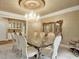 Formal dining room featuring a glass table, ornate mirror, and stunning chandelier at 910 Renaissance Way, Roswell, GA 30076