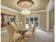 Formal dining room with glass table, ornate mirror, and elegant chandelier at 910 Renaissance Way, Roswell, GA 30076