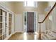 Inviting foyer featuring hardwood floors, decorative doors, and a staircase at 910 Renaissance Way, Roswell, GA 30076