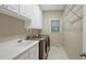 Laundry room with machines, a utility sink and white storage cabinets at 910 Renaissance Way, Roswell, GA 30076